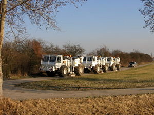 3 Vibrofahrzeuge (Seitenansicht) auf einem Feldweg